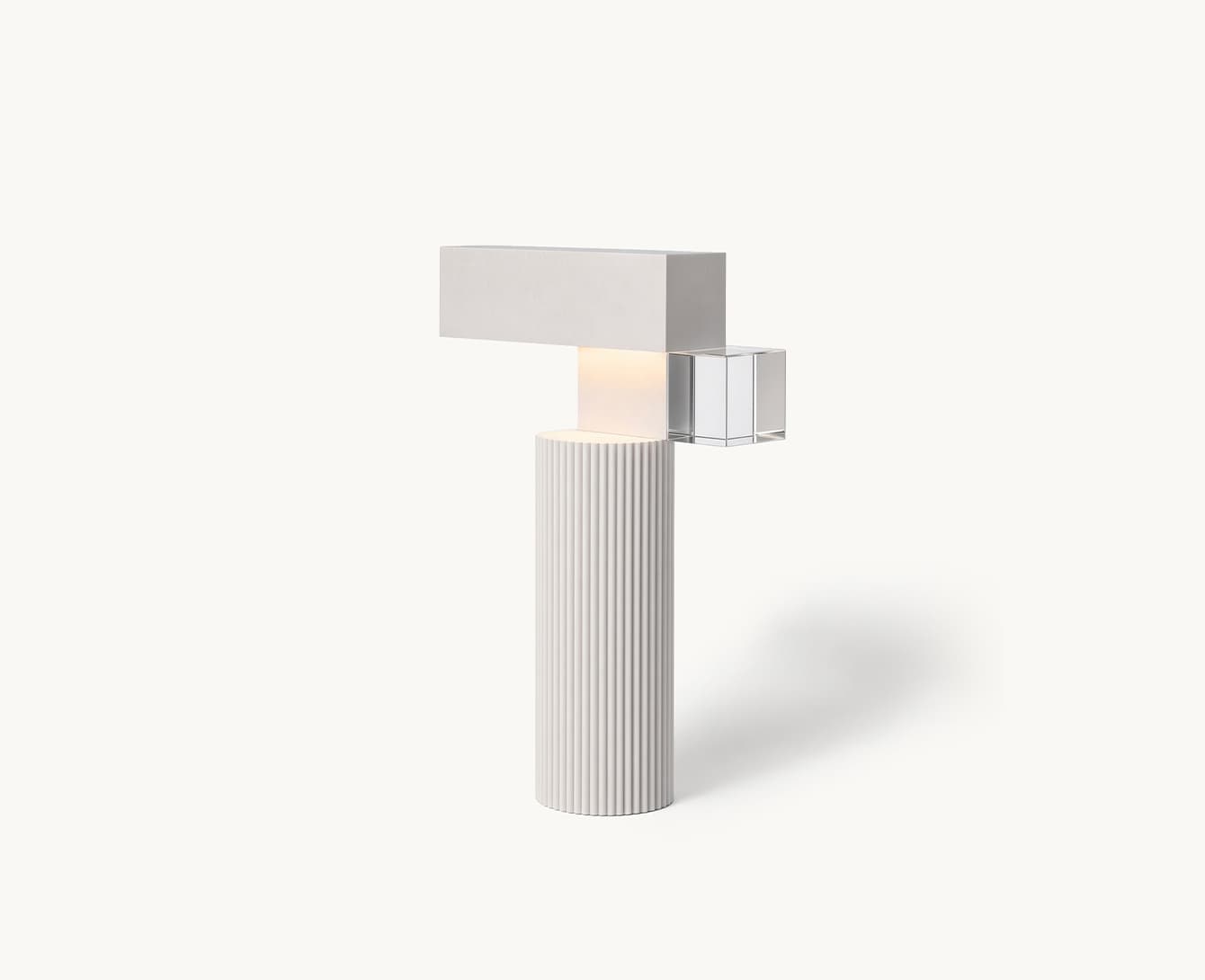 A fluted white column with a beam laid across it and a glass cube resting where the two meet, lit warm at the joint.